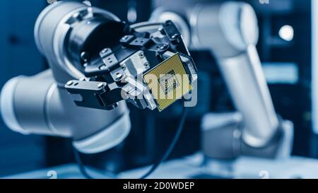 Moderno High Tech autentico braccio robot che tiene contemporaneo Super computer processore. Chip della CPU di supporto dell'effettore terminale del manipolatore robotico industriale Foto Stock