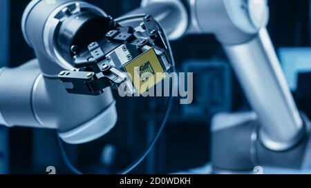 Moderno High Tech autentico braccio robot che tiene contemporaneo Super computer processore. Chip della CPU di supporto dell'effettore terminale del manipolatore robotico industriale Foto Stock