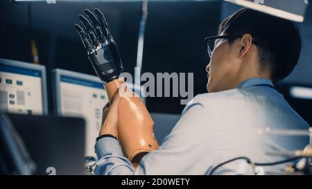 Primo piano di un braccio robotico futuristico sottoposto a test Da un ingegnere giapponese professionista di sviluppo in un High Tech Laboratorio di ricerca con Foto Stock