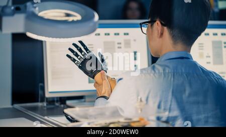 Primo piano di un braccio robotico futuristico sottoposto a test Da un ingegnere giapponese professionista di sviluppo in un High Tech Laboratorio di ricerca con Foto Stock