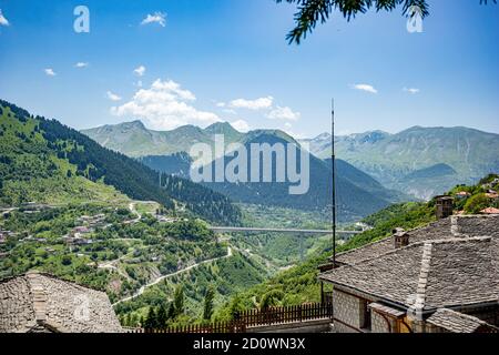 Paesaggio primaverile vista ad alto angolo, tetti e valle dalla città di Metsovo, Epiro, Grecia. La struttura è popolare stazione sciistica invernale greca con vecchie case in stile balcanico Foto Stock