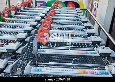 Berlino, Germania - 3 ottobre 2020: Vista di una fila di carrelli per lo shopping di fronte a un negozio. Sulla vettura è presente una lente d'ingrandimento che consente di effettuare visivamente l'ingrandimento Foto Stock