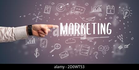 Primo piano di mano tagliata che punta all'iscrizione DI MARKETING, concetto di soluzione aziendale moderna Foto Stock