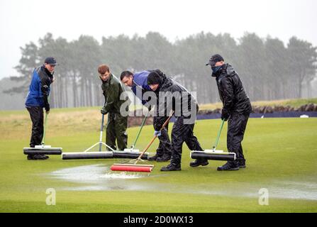 Il personale di terra ha pulito il verde acquerello il 18 a causa della pioggia pesante durante il terzo round dell'Aberdeen Standard Investments Scottish Open al Renaissance Club, North Berwick. Foto Stock