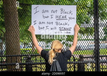 Il protestore che tiene in su un segno a Black Lives la protesta della materia In DC Foto Stock
