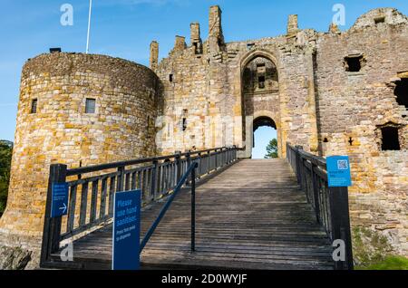 Covid-19 si accorge dell'igienizzatore a mano all'ingresso del castello di Dirleton rovinato sopra il fossato, East Lothian, Scozia, Regno Unito Foto Stock