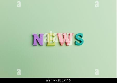 la parola -news- sta mentendo su sfondo verde chiaro fatto lettere non colorate Foto Stock