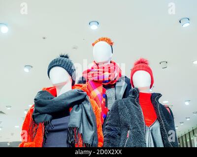 Tre manichini astratti in abiti invernali. Foto sotto sullo sfondo del soffitto Foto Stock