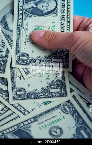 la mano femminile sta tenendo molte banconote da un dollaro, foto a colori verticali Foto Stock