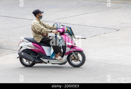 SAMUT PRAKAN, THAILANDIA, 23 2020 LUGLIO, UN uomo asiatico più anziano guida una moto Foto Stock