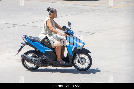 SAMUT PRAKAN, THAILANDIA, 23 2020 LUGLIO, UNA donna asiatica più anziana guida una moto Foto Stock