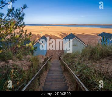 beach capanne e spiaggia di sabbia a pozzi vicino al mare sulla costa nord del norfolk regno unito sole invernale inghilterra Foto Stock