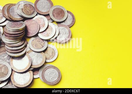 Concetto di risparmio finanziario. Primo piano foto di monete metallo denaro su sfondo giallo, risparmi, guadagni, concetto di stipendio Foto Stock