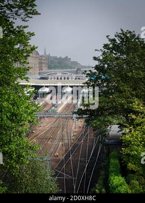 Vista della stazione di Waverley tra gli alberi di Edimburgo in una giornata di nebbia, in Scozia Foto Stock