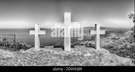 Le tre Iconiche Croci sulla cima del Monte Sant'Elia si affacciano sulla città di Palmi sul Mar Tirreno, in Italia Foto Stock