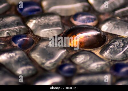Primo piano di una bella pietra di vetro arancione tra l'altro pietre di vetro Foto Stock