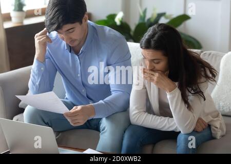 Pensieroso giovane famiglia pensiva studiando documenti finanziari di ottenere ipoteca Foto Stock