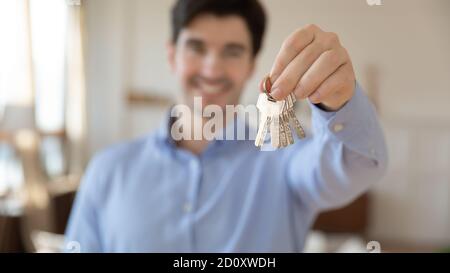 Sorridente agente immobiliare che vi dà le chiavi da appartamento acquistato Foto Stock