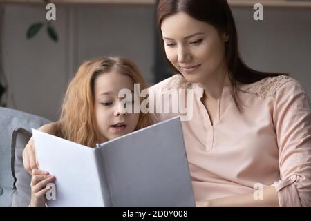 Primo piano amare madre e bambina leggere libro insieme Foto Stock