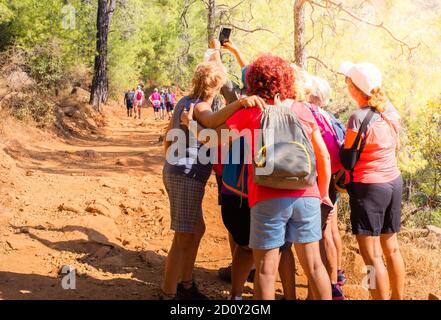 Gruppo di donne anziane che fanno selfie durante l'inseguimento nella foresta di sole. Foto Stock