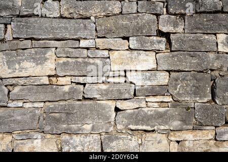 Sfondo di un vecchio e logoro muro di pietra naturale Foto Stock