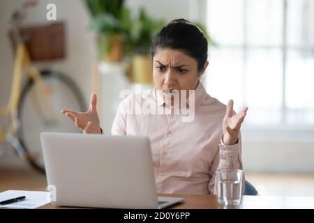 Infelice giovane donna indiana frustrato dal problema del portatile Foto Stock