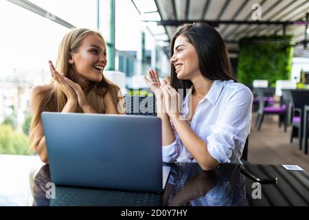 Due donne che utilizzano il computer portatile in un coffee shop Foto Stock