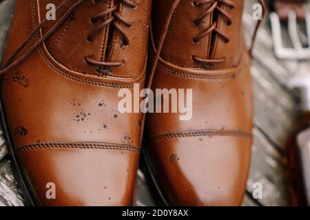 Primo piano di scarpe oxford marroni da uomo con gocce di pioggia. Foto Stock