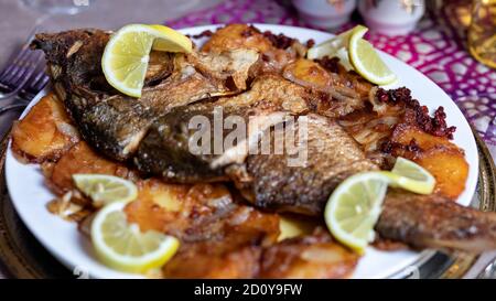 Pesce intero grigliato con un primo piano di limone Foto Stock