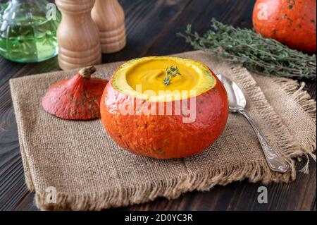 Zuppa di zucca servita nella zucca hokkaido scavata Foto Stock