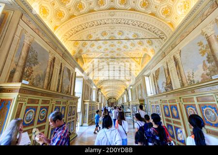 Ampia vista panoramica di persone che camminano attraverso una galleria di corridoi ornati nella Biblioteca Apostolica Vaticana, parte dei Musei Vaticani di Roma. Foto Stock