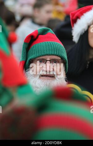 Faccia nella folla pensionato Billy mandria con Elf cappello acceso Foto Stock