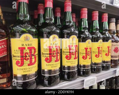 Scaffali del supermercato pieni di marca J e B. Bottiglie di whiskey Foto Stock