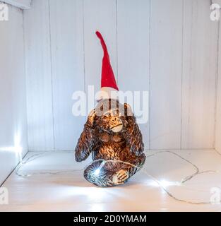 Le tre Sculpture scimmie non sentire natale decokation cappello e luci di santa. Foto Stock
