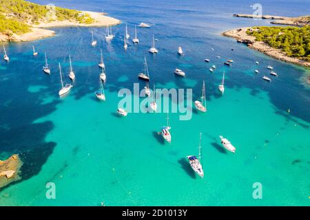 La foto del 28 luglio 2020 mostra le barche ormeggiate nel Mar Mediterraneo nella baia di Portinatx a Ibiza, parte delle Isole Baleari spagnole, che è popolare tra le famiglie britanniche, ma è ora una zona no go per i turisti britannici. Le barche sono normalmente utilizzate per escursioni giornaliere, ma il la mancanza di turisti significa che sono licenziati per il momento. Foto Stock