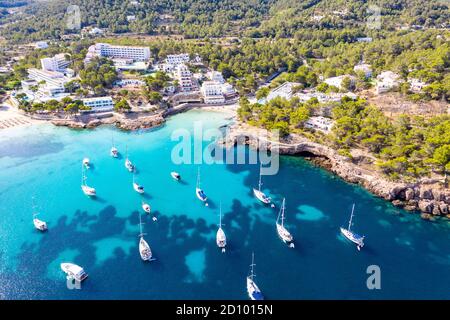 La foto del 28 luglio 2020 mostra le barche ormeggiate nel Mar Mediterraneo nella baia di Portinatx a Ibiza, parte delle Isole Baleari spagnole, che è popolare tra le famiglie britanniche, ma è ora una zona no go per i turisti britannici. Le barche sono normalmente utilizzate per escursioni giornaliere, ma il la mancanza di turisti significa che sono licenziati per il momento. Foto Stock