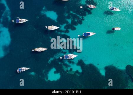 La foto del 28 luglio 2020 mostra le barche ormeggiate nel Mar Mediterraneo nella baia di Portinatx a Ibiza, parte delle Isole Baleari spagnole, che è popolare tra le famiglie britanniche, ma è ora una zona no go per i turisti britannici. Le barche sono normalmente utilizzate per escursioni giornaliere, ma il la mancanza di turisti significa che sono licenziati per il momento. Foto Stock