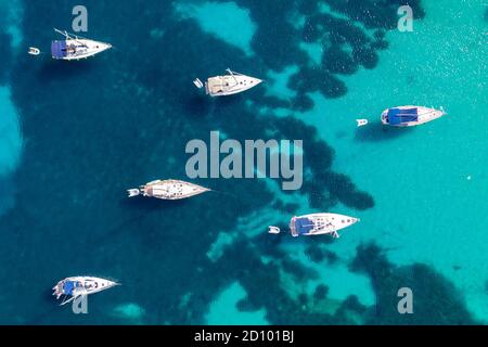 La foto del 28 luglio 2020 mostra le barche ormeggiate nel Mar Mediterraneo nella baia di Portinatx a Ibiza, parte delle Isole Baleari spagnole, che è popolare tra le famiglie britanniche, ma è ora una zona no go per i turisti britannici. Le barche sono normalmente utilizzate per escursioni giornaliere, ma il la mancanza di turisti significa che sono licenziati per il momento. Foto Stock