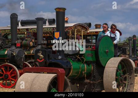 Costante come lei va … Un equipaggio esperto ai comandi di Aveling & Porter Road Roller No. 11975, costruito nel 1927 a Rochester, Kent, come clanks e puffs, volano verde che gira, nell'arena di esposizione al 50th Anniversary Woodcote Steam & Vintage Transport Rally nel luglio 2013 a Woodcote, Oxfordshire, Inghilterra, UK. Foto Stock