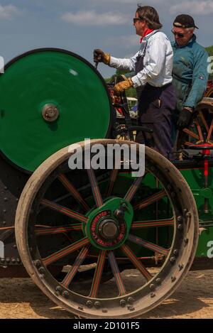 Costante come lei va … Un equipaggio esperto ai comandi di Aveling & Porter Road Roller No. 11975, costruito nel 1927 a Rochester, Kent, come clanks e puffs, volano verde che gira, nell'arena di esposizione al 50th Anniversary Woodcote Steam & Vintage Transport Rally nel luglio 2013 a Woodcote, Oxfordshire, Inghilterra, UK. Foto Stock