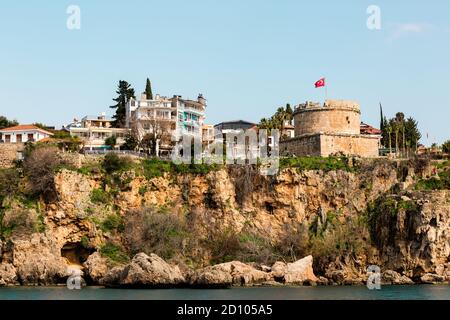 Antalya, Turchia - 22 febbraio 2019: Vecchia torre fortificazione con bandiera della Turchia nel centro storico di Kaleici ad Antalya. Foto Stock