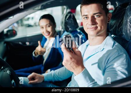 Uomo che mostra le chiavi elettroniche dell'automobile Foto Stock
