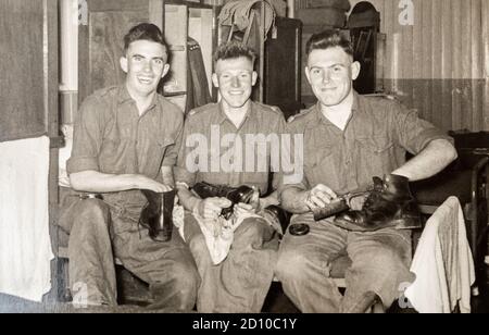 Tre reclute del servizio nazionale che lucidano i loro stivali nelle loro caserme, RAMC, 1956, Ash vale, Surrey, Inghilterra, Regno Unito Foto Stock