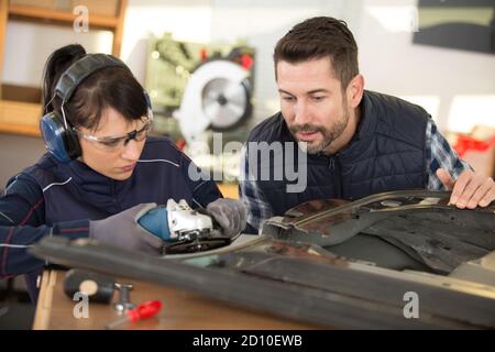 Giovane maschio e femmina tecnici nella fabbrica di carpenterie metalliche Foto Stock
