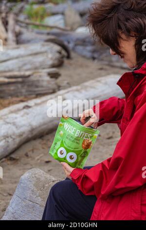 Donna fuori per una passeggiata e gustando uno spuntino sano A Steveston British Columbia Canada Foto Stock