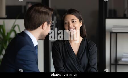 Sorridente gente multirazziale di affari che comunica in ufficio. Foto Stock