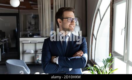 Felice sorridente giovane uomo d'affari che guarda a distanza. Foto Stock