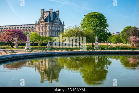 Vista panoramica del Parco delle Tuileries e del Louvre con fiori, statue, fontana e fiori di ciliegio durante il mese di aprile - primavera a Parigi, Francia. Foto Stock