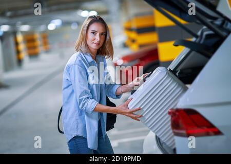 Donna adulta turistica nel parcheggio sotterraneo dell'aeroporto Foto Stock