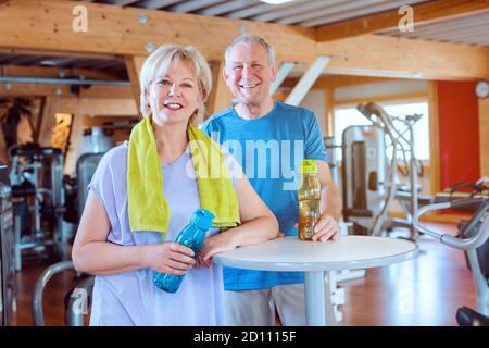 Due anziani avente una pausa dall'esercizio in palestra Foto Stock